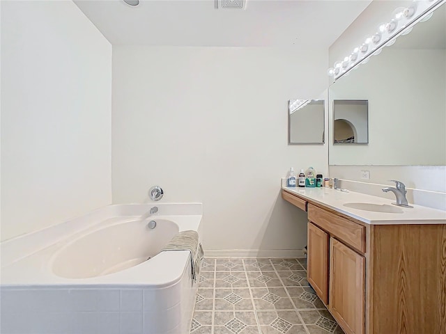 bathroom with tile patterned floors, tiled tub, and vanity