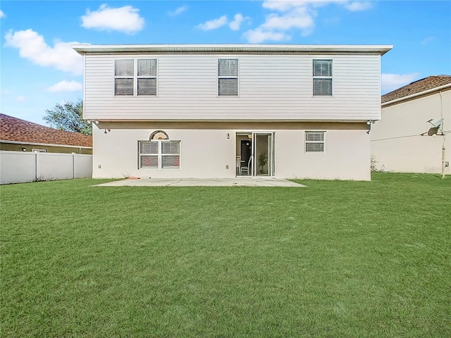 rear view of house featuring a lawn and a patio