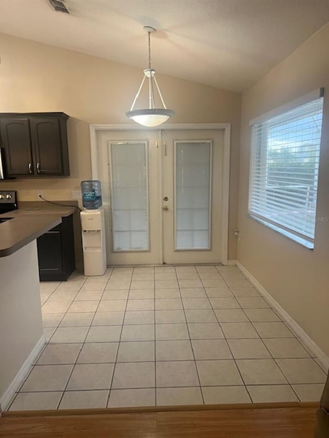 unfurnished dining area with light tile patterned flooring and lofted ceiling