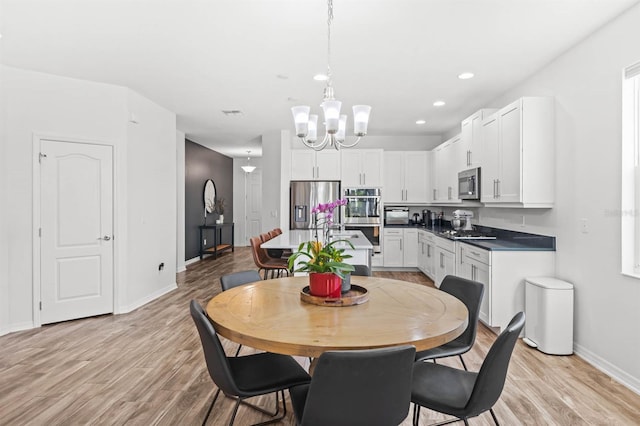 dining area featuring a notable chandelier and light wood-type flooring