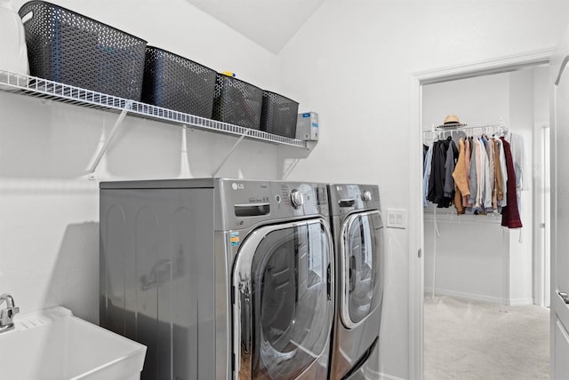 laundry area featuring washer and clothes dryer, sink, and light colored carpet