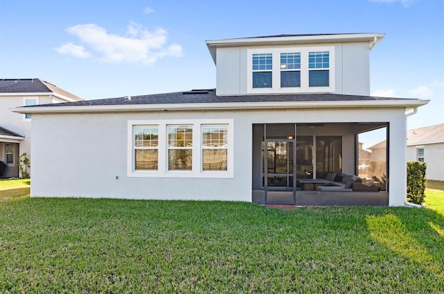 back of property with a sunroom and a lawn