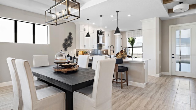 dining space with light hardwood / wood-style flooring and a chandelier