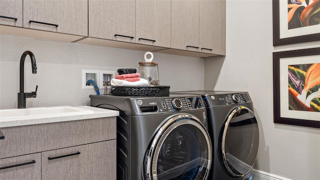 laundry room featuring sink, cabinets, and washing machine and dryer