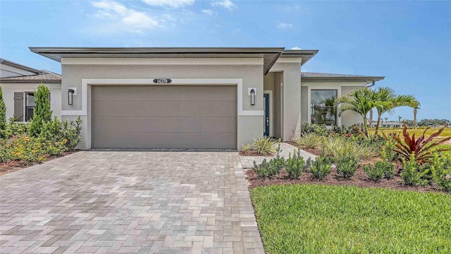 14370 Hammock Oak St, Parrish, FL 34219 - view of front of home featuring stucco siding, decorative driveway, and a garage