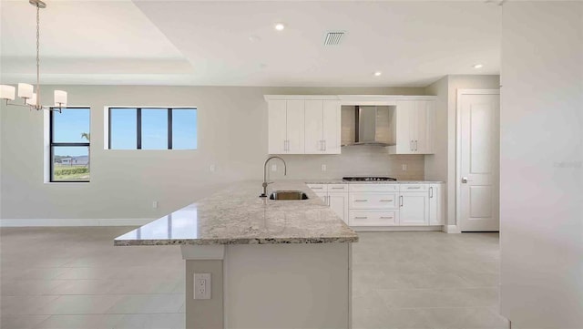 14370 Hammock Oak St, Parrish, FL 34219 - kitchen featuring a sink, wall chimney exhaust hood, light tile patterned flooring, decorative backsplash, and white cabinetry