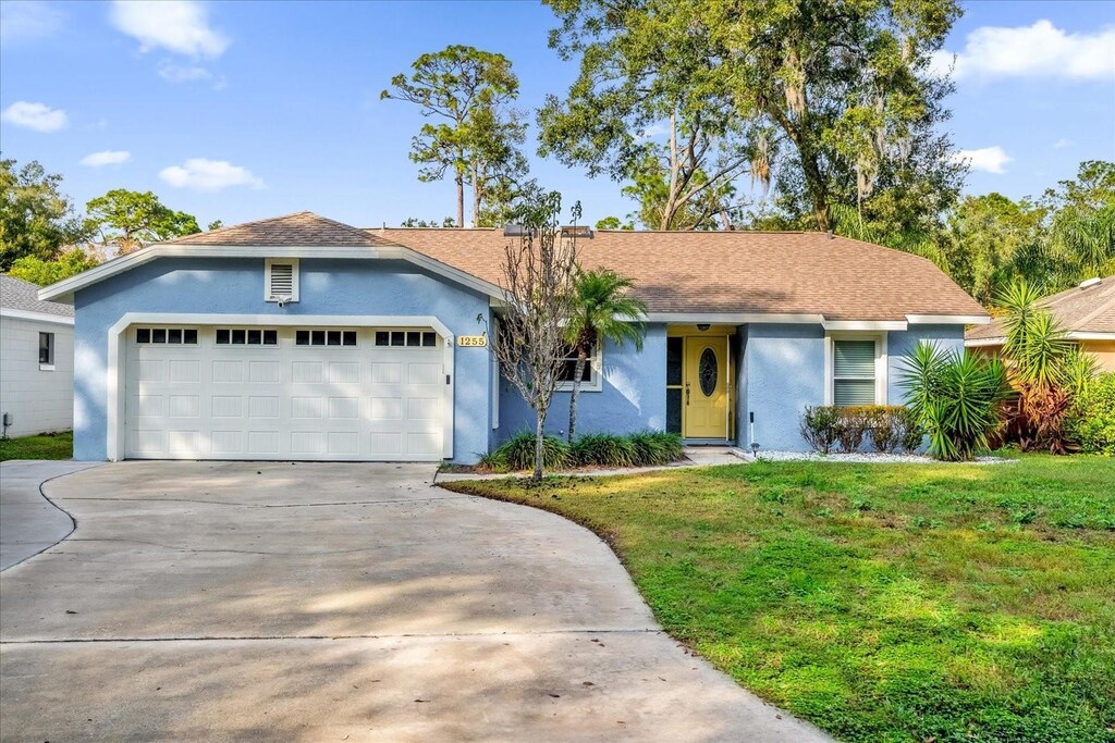 view of front of property featuring a front lawn and a garage