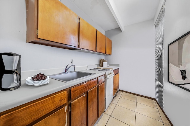 kitchen featuring light tile patterned floors, sink, and gas range gas stove