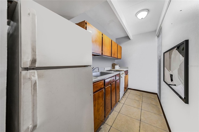 kitchen with sink, light tile patterned floors, and white appliances