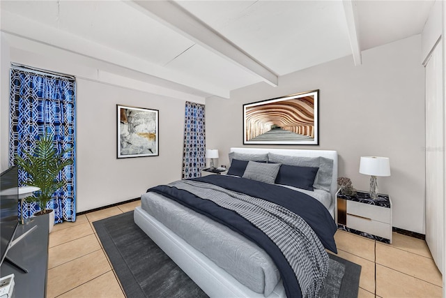 bedroom featuring light tile patterned floors and beam ceiling