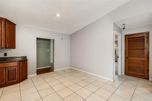 interior space with light tile patterned flooring and lofted ceiling