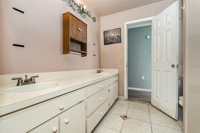 bathroom with toilet, vanity, and tile patterned floors