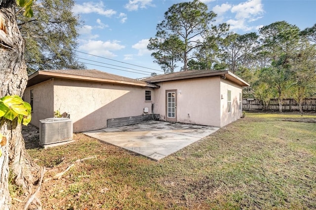 back of property featuring cooling unit, a patio area, and a lawn