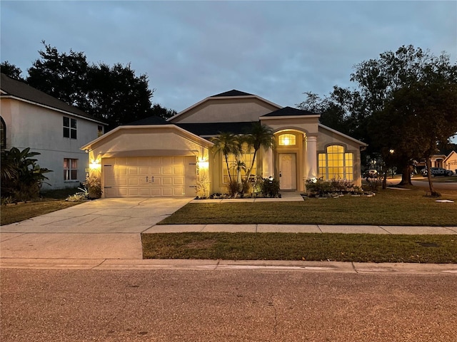 view of front of home with a front yard and a garage