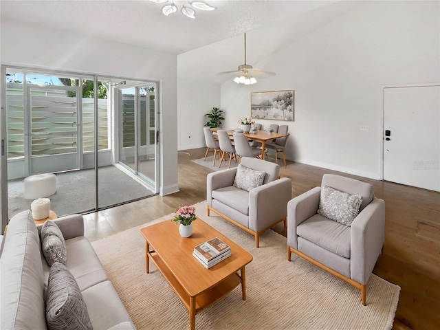 living room featuring light hardwood / wood-style floors, ceiling fan, and lofted ceiling