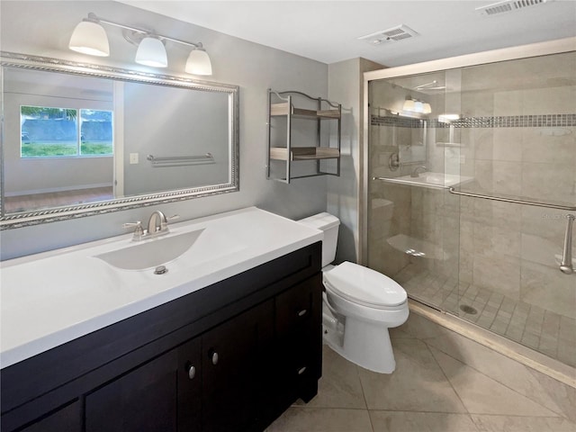 bathroom with tile patterned floors, vanity, an enclosed shower, and toilet