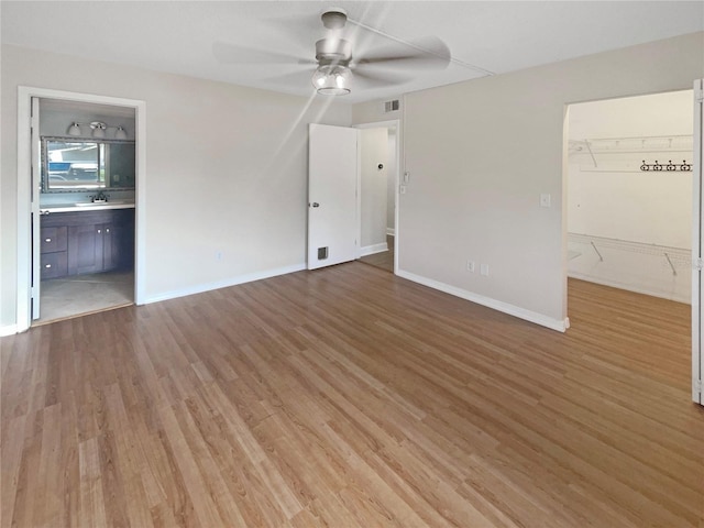 unfurnished room featuring ceiling fan, wood-type flooring, and sink