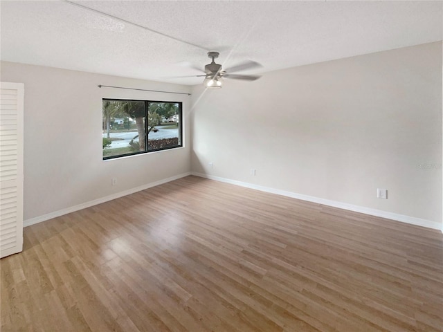 spare room with ceiling fan, a textured ceiling, and hardwood / wood-style flooring