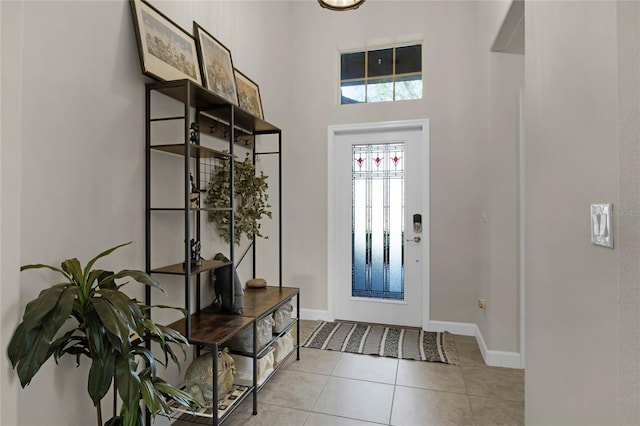 tiled foyer entrance with a towering ceiling