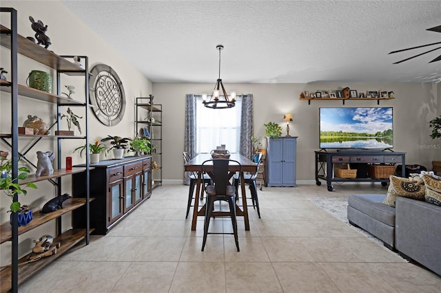 dining room featuring a textured ceiling, light tile patterned floors, and ceiling fan with notable chandelier