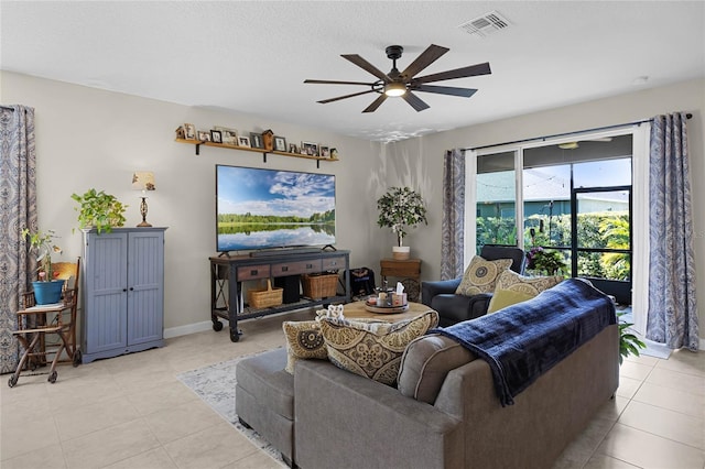 tiled living room featuring ceiling fan and a textured ceiling