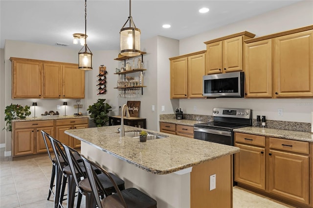 kitchen with stainless steel appliances, a kitchen island with sink, a breakfast bar area, and sink