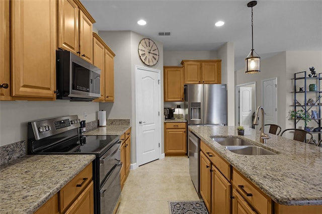 kitchen featuring light stone countertops, sink, stainless steel appliances, a kitchen island with sink, and light tile patterned floors