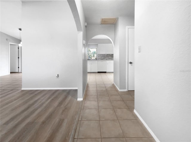 hallway with tile patterned floors and sink