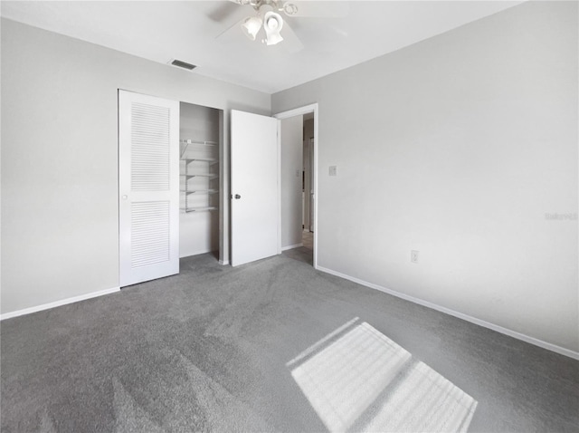 unfurnished bedroom featuring ceiling fan, dark carpet, and a closet