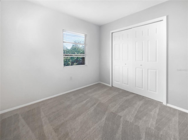 unfurnished bedroom featuring carpet floors and a closet