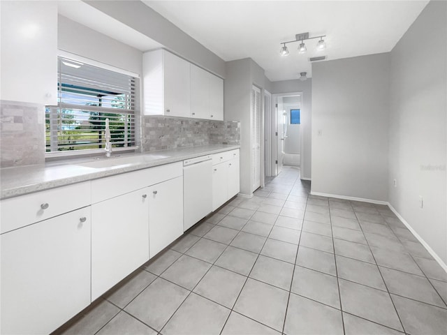 kitchen with tasteful backsplash, white cabinets, sink, and white dishwasher