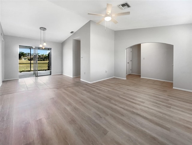 empty room featuring light wood-type flooring, ceiling fan, and lofted ceiling