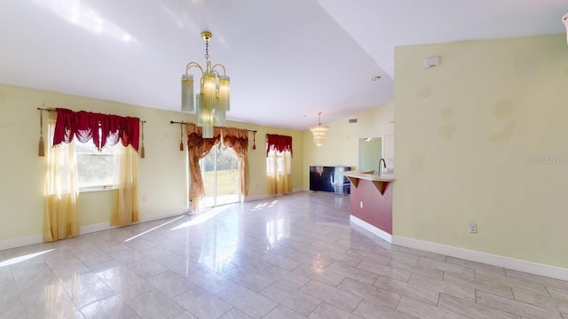 unfurnished room with light tile patterned floors, sink, lofted ceiling, and a notable chandelier