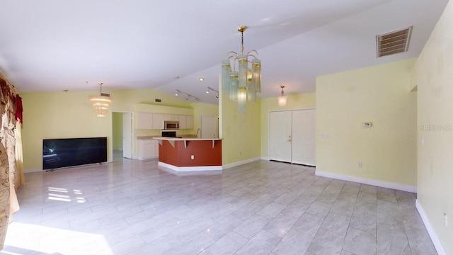 unfurnished living room with vaulted ceiling, a stone fireplace, and an inviting chandelier