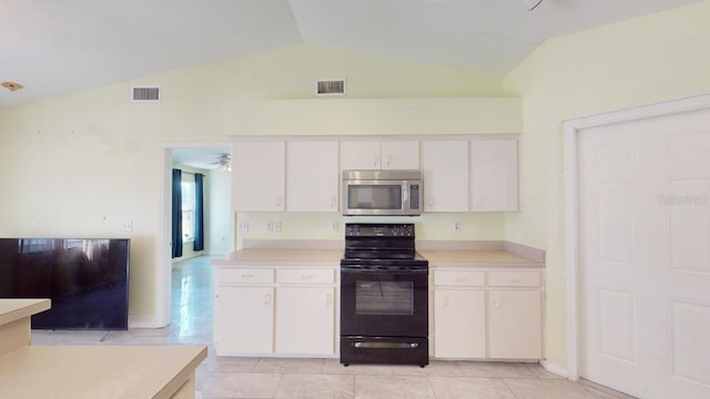 kitchen with electric range, white cabinetry, and lofted ceiling