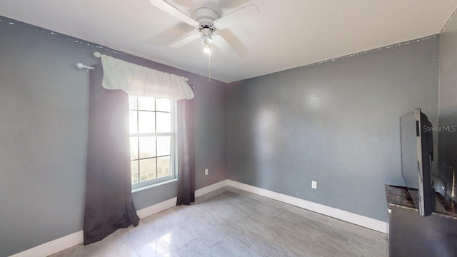 spare room featuring ceiling fan and plenty of natural light