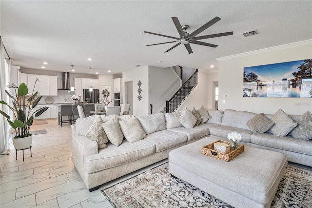 living room featuring a textured ceiling, ceiling fan, and ornamental molding