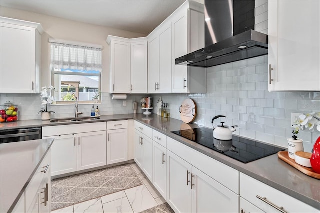 kitchen featuring backsplash, black electric cooktop, sink, wall chimney range hood, and white cabinets