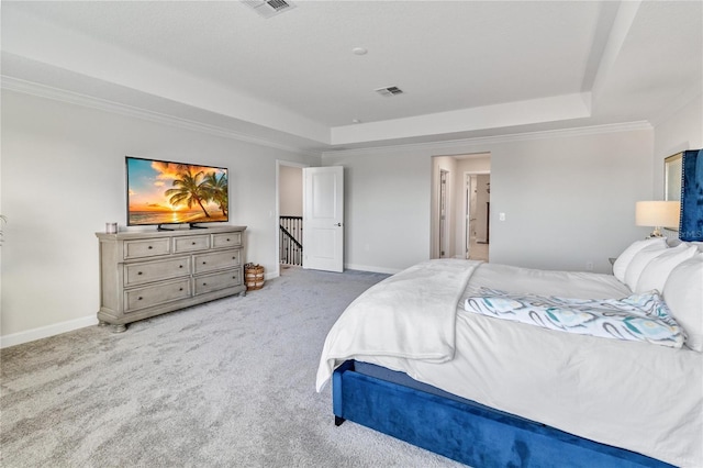 bedroom with a raised ceiling, crown molding, and carpet flooring