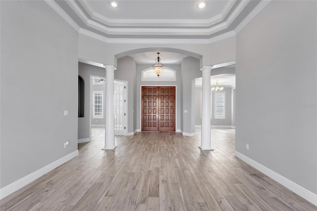 foyer entrance with decorative columns, plenty of natural light, and light hardwood / wood-style floors