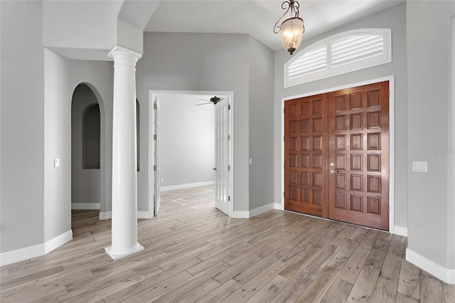 entrance foyer featuring ceiling fan, light hardwood / wood-style floors, and decorative columns