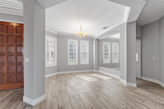 foyer featuring a notable chandelier, crown molding, and light wood-type flooring