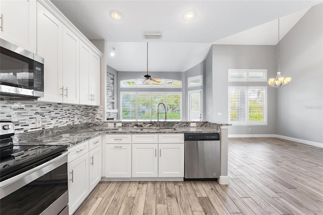 kitchen featuring pendant lighting, stainless steel appliances, sink, and white cabinets