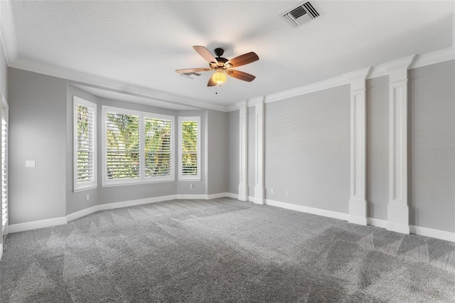 unfurnished room with ornate columns, crown molding, carpet, and ceiling fan