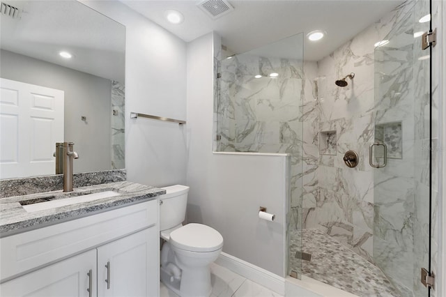 bathroom featuring toilet, vanity, and a shower with shower door