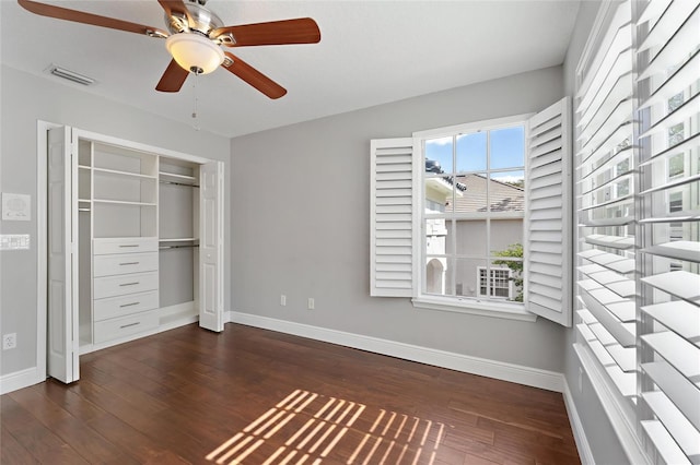 unfurnished bedroom with ceiling fan, dark hardwood / wood-style floors, and a closet