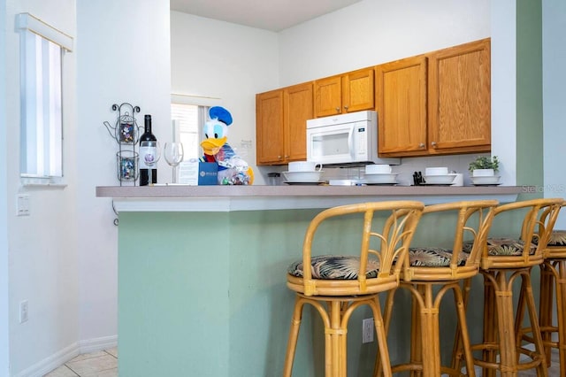 kitchen featuring a kitchen bar and kitchen peninsula