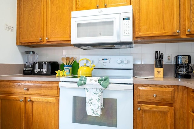 kitchen with tasteful backsplash and white appliances