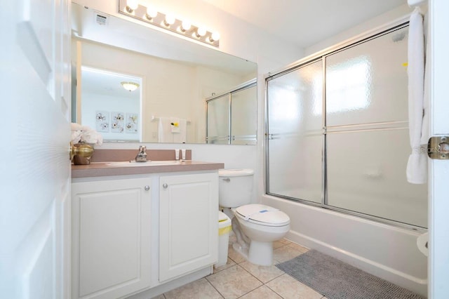 full bathroom featuring vanity, combined bath / shower with glass door, tile patterned floors, and toilet