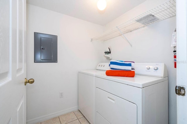 washroom featuring light tile patterned floors, washer and clothes dryer, and electric panel